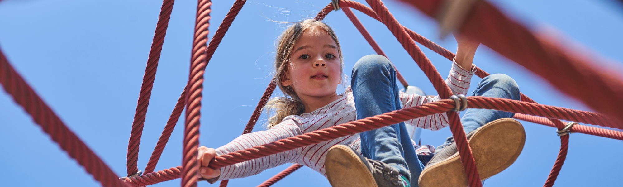 Girl playing in a jungle gym.